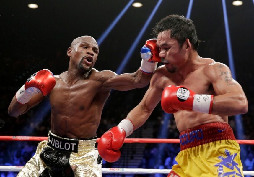 FILE - Floyd Mayweather Jr., left, hits Manny Pacquiao, from the Philippines, during their welterweight title fight on May 2, 2015, in Las Vegas. (AP Photo/Isaac Brekken, File)