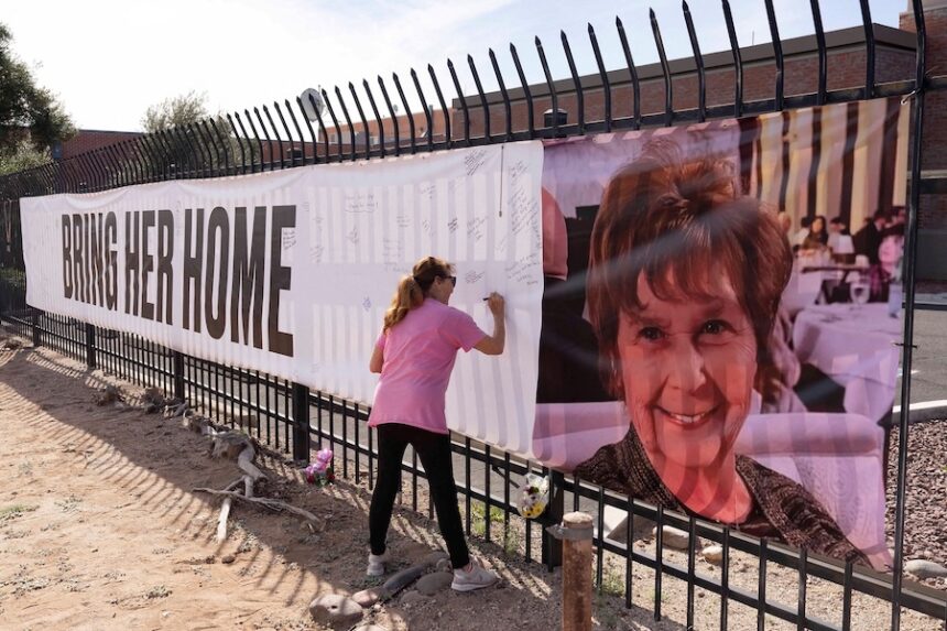 A woman signs a banner in honor of Nancy Guthrie, US television journalist Savannah Guthrie's abducted elderly mother on February 12.
