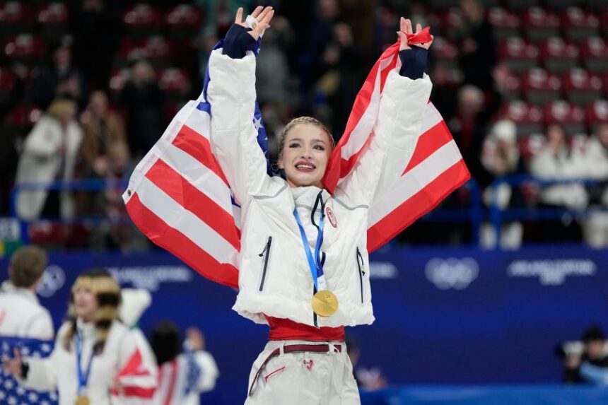 Team USA's Amber Glenn celebrates with her gold medal after the figure skating team event at the 2026 Winter Olympics, in Milan, Italy, Sunday, Feb. 8, 2026. (AP Photo/Ashley Landis)