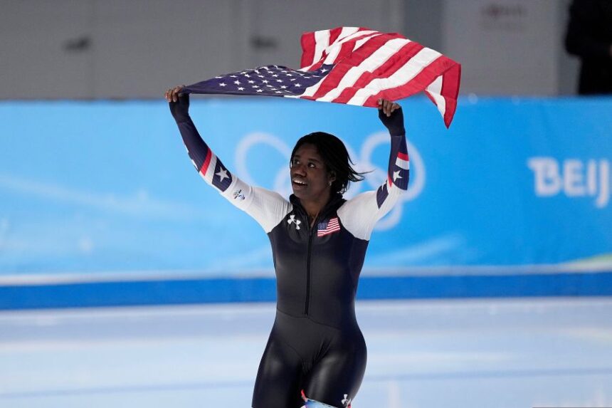 FILE - Erin Jackson of the United States hoists an American flag after winning the gold medal in the speedskating women's 500-meter race at the 2022 Winter Olympics, Sunday, Feb. 13, 2022, in Beijing. (AP Photo/Sue Ogrocki, file)