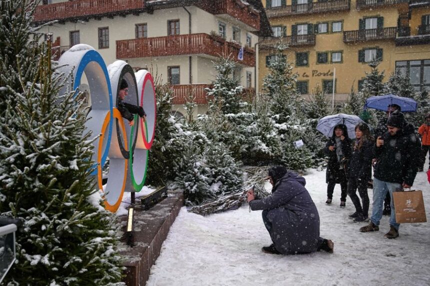 People take photos with the Olympic rings ahead of the 2026 Winter Olympics, in Cortina d'Ampezzo, Italy, Wednesday, Feb. 4, 2026. (AP Photo/Fatima Shbair)