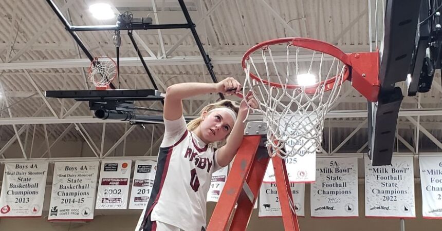 Rigby's Kinzley Larsen cuts down the net as the Trojans celebrated a district title with a win Tuesday over rival Madison. | Allan Steele, EastIdahoSports.com.