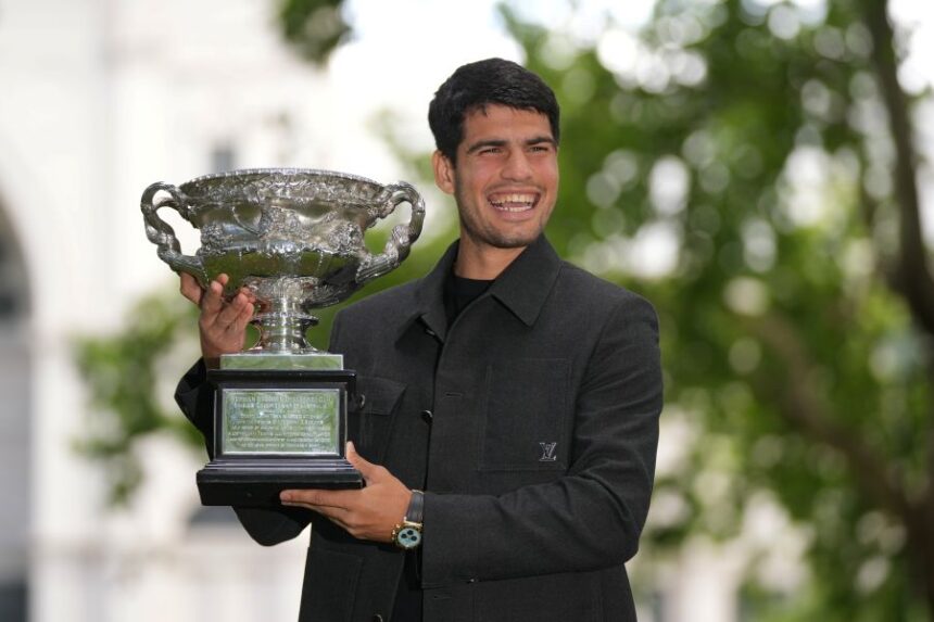 Carlos Alcaraz of Spain smiles as he poses with the Norman Brookes Challenge Cup the morning after defeating Novak Djokovic of Serbia in the men's singles final at the Australian Open tennis championship, in Melbourne, Australia, Monday, Feb. 2, 2026. (AP Photo/Dita Alangkara)