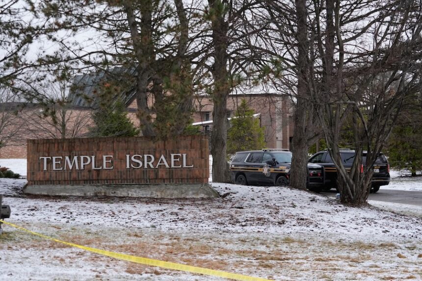 Police vehicles sit outside the Temple Israel synagogue Friday, March 13, 2026, in West Bloomfield Township, Mich.