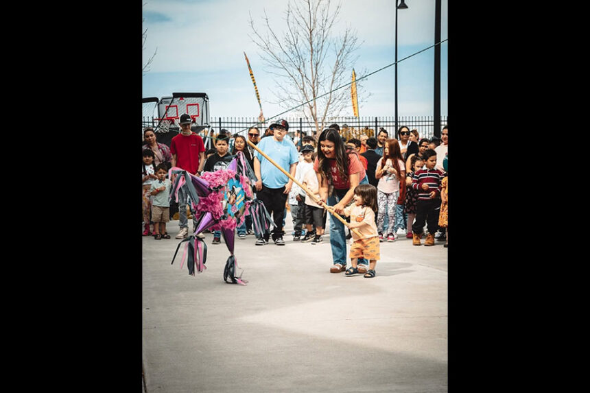 A child, being aided by a parent, attempting to hit a pinata at Calakas Tacos & Miches's Cinco de Mayo event in 2025. | Courtesy Liliana Sanchez