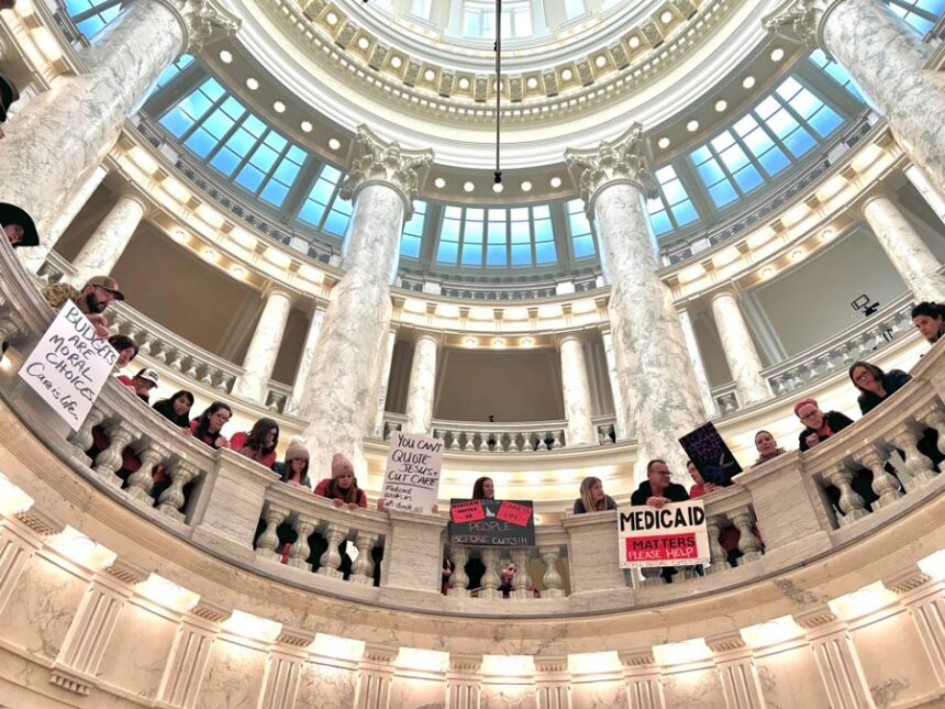 Hundreds of Idahoans gathered in the rotunda of the Idaho Capitol on Jan. 12, 2026, to protest budget cuts to the state’s Medicaid program. The protest, organized by Idaho Voices for Children, took place before the governor’s State of the State Address. | Christina Lords, Idaho Capital Sun
