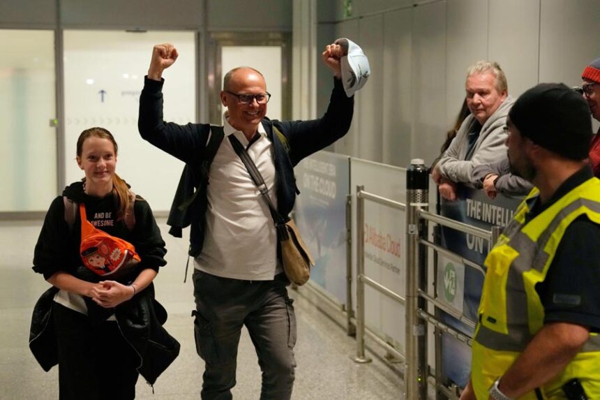 A man celebrates as he arrives at the International Airport in Frankfurt, Germany, after being evacuated from Dubai on a commercial flight, Tuesday, March 3, 2026. (AP Photo/Michael Probst)