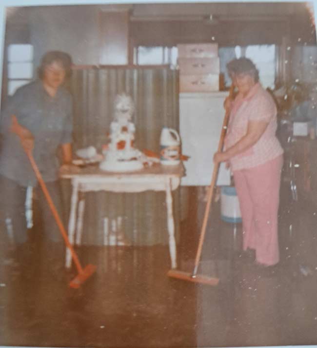 McNabb family photo showing two family members involved in the cleanup. Gerald and Millie's wedding cake is on the table.
