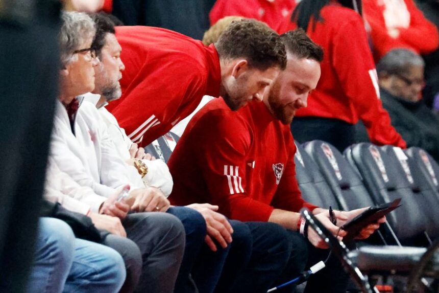 North Carolina States' Reed Vial, left, and Patrick Stacy, center, watch a replay during the first half of an NCAA college basketball game against Duke in Raleigh, N.C., Monday, March 2, 2026. (AP Photo/Karl DeBlaker)