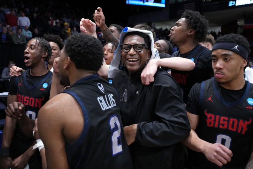 Howard head coach Kenneth Blakeney, center, and Howard players celebrate at the conclusion of the second half in a First Four college basketball game in the NCAA Tournament against UMBC, Tuesday, March 17, 2026, in Dayton, Ohio. (AP Photo/Kareem Elgazzar)