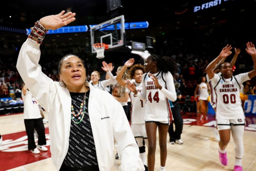 South Carolina head coach Dawn Staley, left, leads her team in waving to supporters after defeating Southern California in the second round of the NCAA college basketball tournament, Monday, March 23, 2026, in Columbia, S.C. (AP Photo/Nell Redmond)