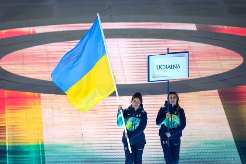 A volunteer holds the Ukrainian flag to take part in the opening ceremony at the 2026 Winter Paralympics, in Verona, Italy, Friday, March 6, 2026. (AP Photo/Luca Bruno)