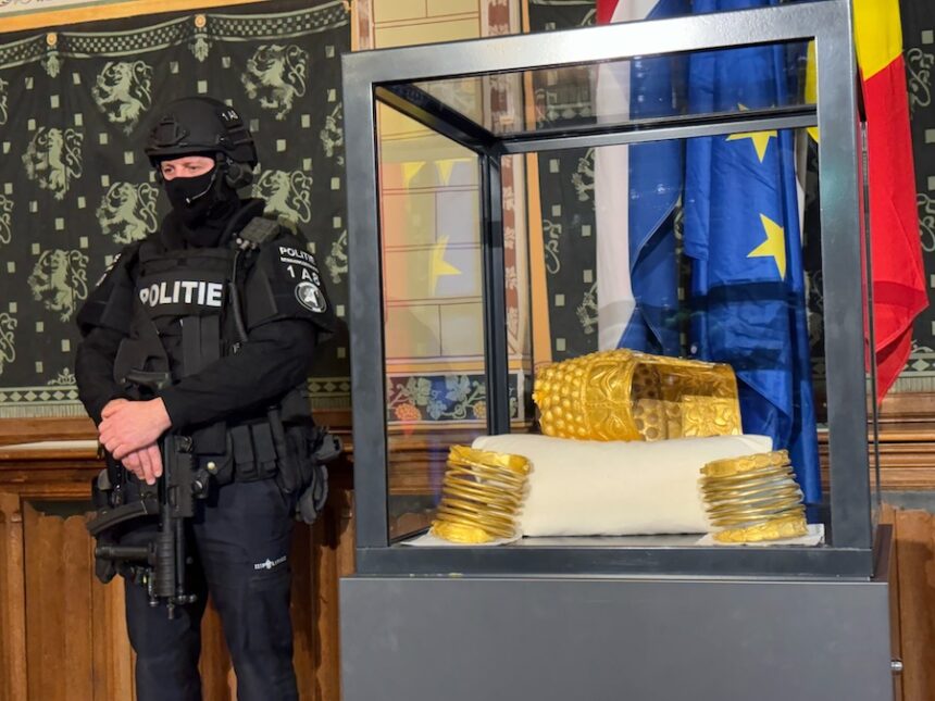 A Police officer stands by a stolen artefact from Romania, the 2,500-year-old Cotofenesti helmet, recovered in Netherlands, is shown during a press conference in Assen, Netherlands, Thursday, April 2, 2026.
