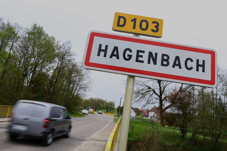 A car drives past a road sign at the entrance of Hagenbach where a 9-year-old boy was rescued this week after living locked in his father's utility van since 2024, Eastern France, Saturday, April 11, 2026.