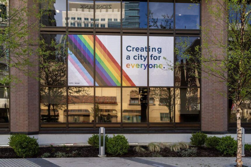After removing pride flags at Boise City Hall, per new laws passed by the Idaho Legislature, the flagpoles are now rainbow striped and a sign is visible in a window on the front of the building on Tuesday. (Darin Oswald)