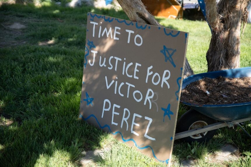 A sign sits in the yard where Victor Perez was shot in Pocatello by police.