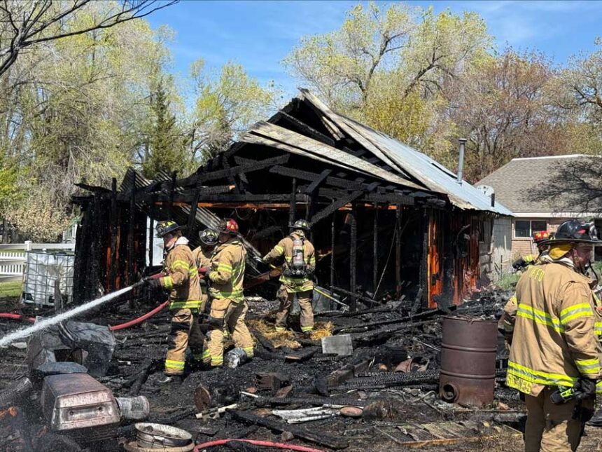 Firefighters work to put out hot spots after extinguishing a fire that destroyed a shed in Idaho Falls on Sunday.