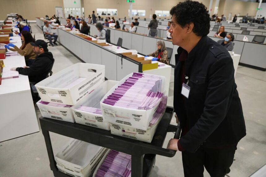 A worker pushes a cart of received mail ballots at the L.A. County Ballot Processing Center Nov. 4, 2025, in City of Industry, Calif. (AP Photo/Ethan Swope, File)