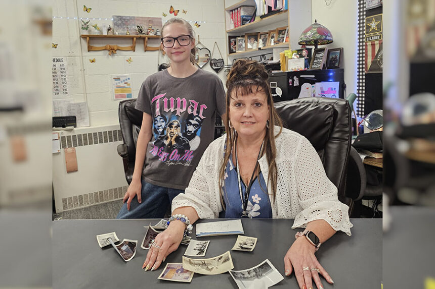 Rebecca Morgan, a teacher at Hobbs Middle School, and her student Mageigh Hayes, are seen with 12 pictures that they're trying to return back to the owner.