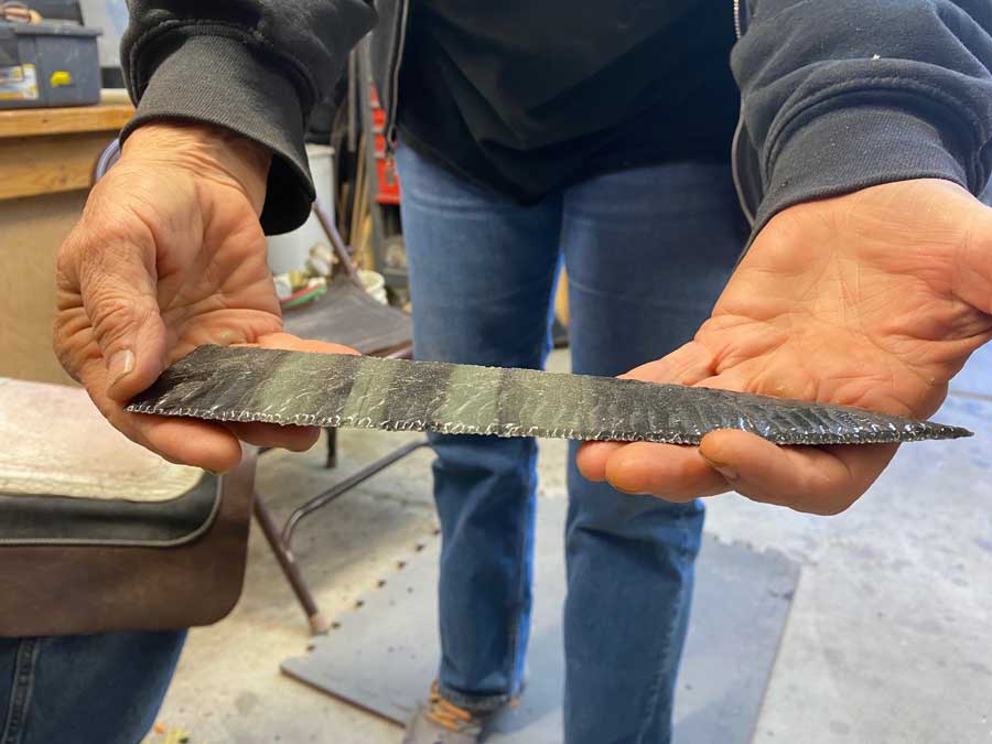 A club member displaying a knife blade knapped out of obsidian.