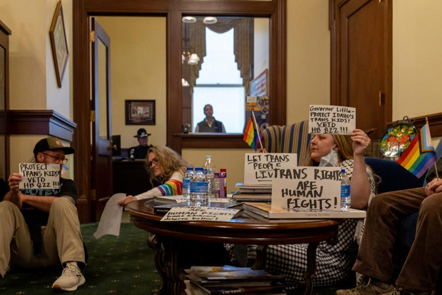 Minutes before protestors were arrested after staying in Idaho Gov. Brad Little’s office after it closed, they held up signs — urging the governor to veto an anti-trans bill on Wednesday, April 1, 2026. | Kyle Pfannenstiel, Idaho Capital Sun