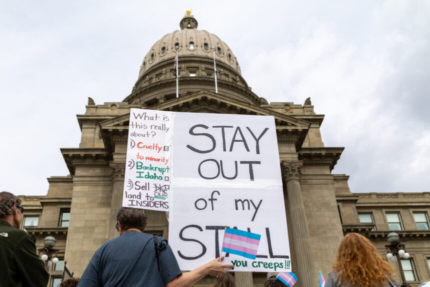 At a Transgender Day of Visibility rally on March 31, 2026, in front of the Idaho State Capitol in Boise, a person holds a sign criticizing the Legislature’s criminal ban on transgender people using bathrooms that align with their gender identity. | Kyle Pfannenstiel, Idaho Capital Sun