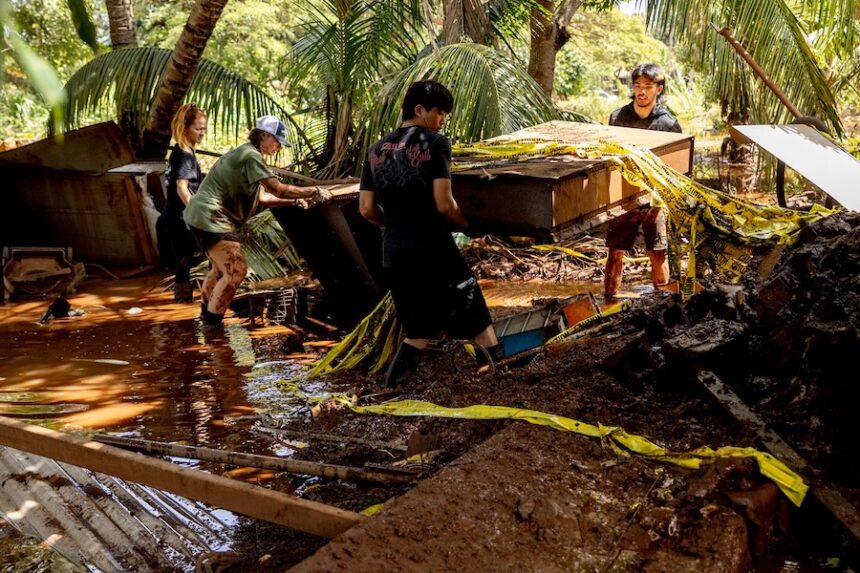 Volunteers carry debris from a home impacted by flooding in Haleiwa, Hawaii, on March 22.
