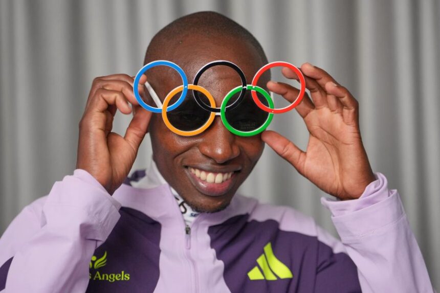 Kenya's Sabastian Sawe poses with Olympic Ring sun-glasses during an interview with The Associated Press after winning the London Marathon, in London, Monday, April 27, 2026. (AP Photo/Kin Cheung)