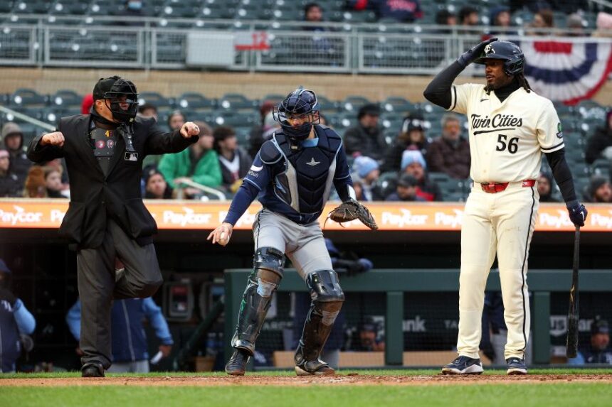 Minnesota Twins' Josh Bell, right, signals for an ABS challenge on a called third strike, which was upheld, during the first inning of baseball game against the Tampa Bay Rays, Saturday, April 4, 2026, in Minneapolis. (AP Photo/Matt Krohn)