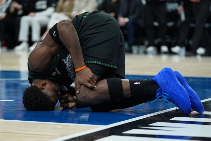 Minnesota Timberwolves guard Anthony Edwards kneels on the court after sustaining an injury during the first half of Game 4 of a first-round NBA basketball playoff series against the Denver Nuggets, Saturday, April 25, 2026, in Minneapolis. (AP Photo/Abbie Parr)