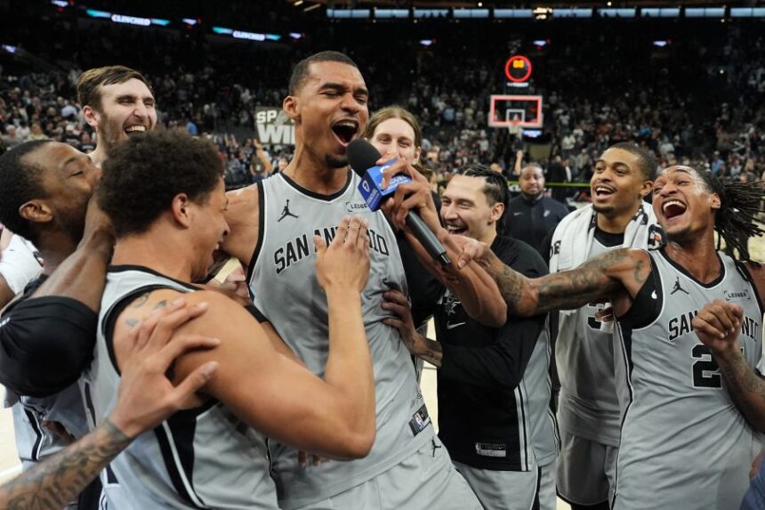 San Antonio Spurs forward Victor Wembanyama, center, celebrates with teammates after he hit a game-winning score against the Phoenix Suns in the final seconds of an NBA basketball game in San Antonio, Thursday, March 19, 2026. (AP Photo/Eric Gay)
