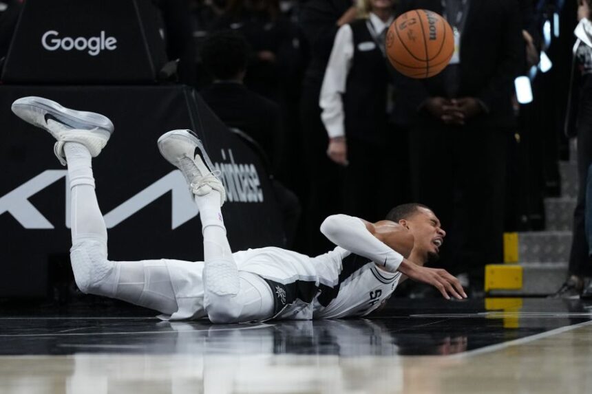 San Antonio Spurs forward Victor Wembanyama (1) takes a hard fall on the court during the first half in Game 2 of a first-round NBA playoffs basketball series against the Portland Trail Blazers in San Antonio, Tuesday, April 21, 2026. (AP Photo/Eric Gay)