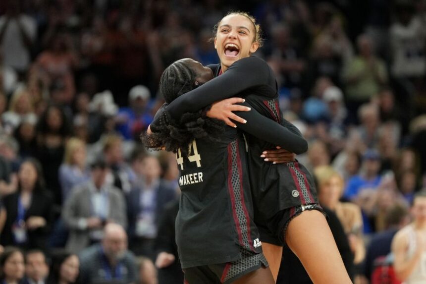 South Carolina guard Tessa Johnson, right, and South Carolina guard Agot Makeer (44) celebrate after defeating UConn in a woman's NCAA college basketball tournament semifinal game at the Final Four, Friday, April 3, 2026, in Phoenix. (AP Photo/Rick Scuteri)