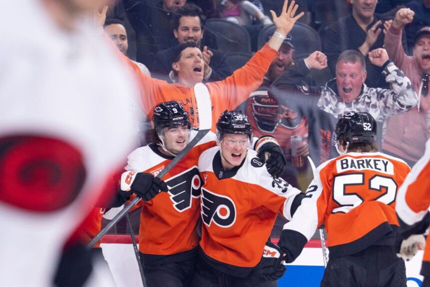 Philadelphia Flyers right winger Matvei Michkov, center, celebrates after his goal with defenseman Jamie Drysdale, left, and center Denver Barkey, right, during the second period of an NHL hockey game against the Carolina Hurricanes, Monday, April 13, 2026, in Philadelphia. (AP Photo/Chris Szagola)