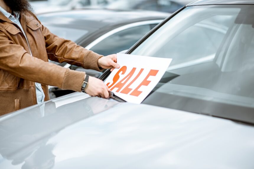 salesperson putting sale plate on the car 2026 03 20 01 01 23 utc