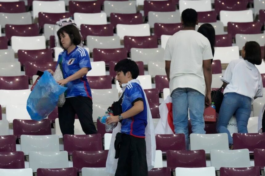 FILE - Japan supporters clean the stands at the end of the World Cup group E soccer match between Germany and Japan, at the Khalifa International Stadium in Doha, Qatar, Wednesday, Nov. 23, 2022. (AP Photo/Eugene Hoshiko, File)