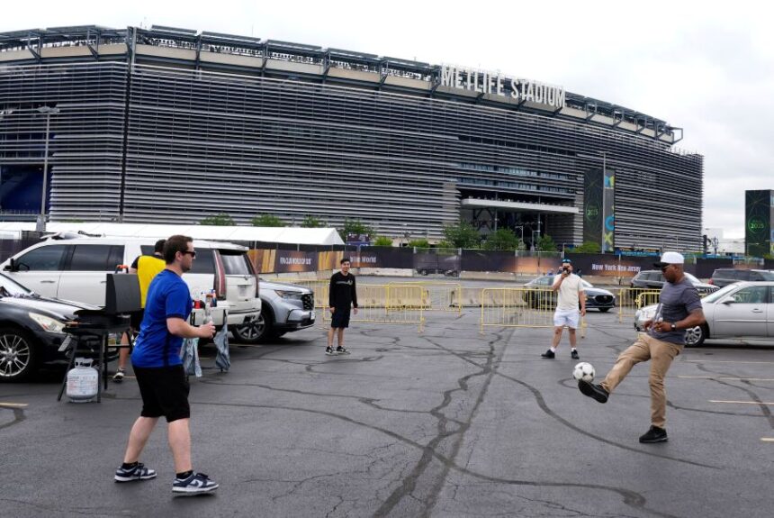 FILE - Fans play with a ball outside the Metlife Stadium prior to the Club World Cup final soccer match between Chelsea and PSG in East Rutherford, N.J., Sunday, July 13, 2025. (AP Photo/Pamela Smith, File)