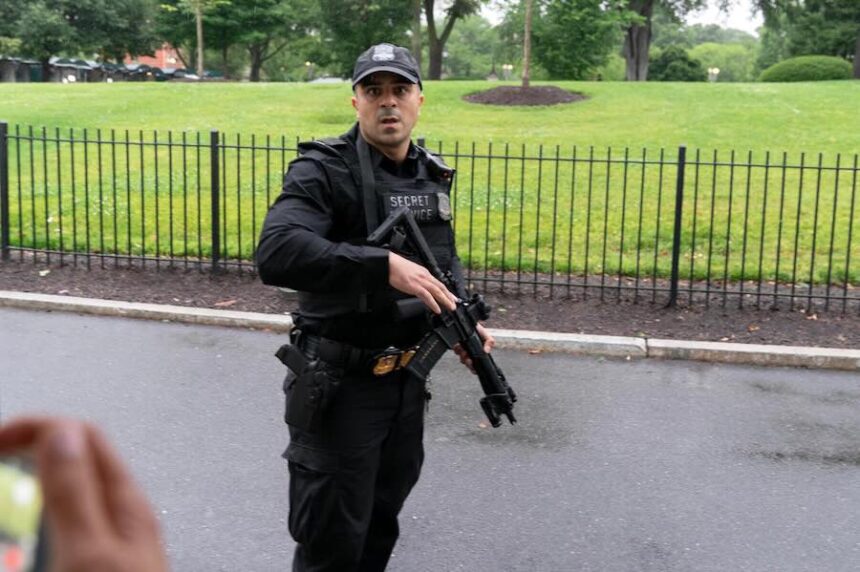 A member of the Secret Service stops journalist from leaving the White House, Saturday, May 23, 2026, in Washington.
