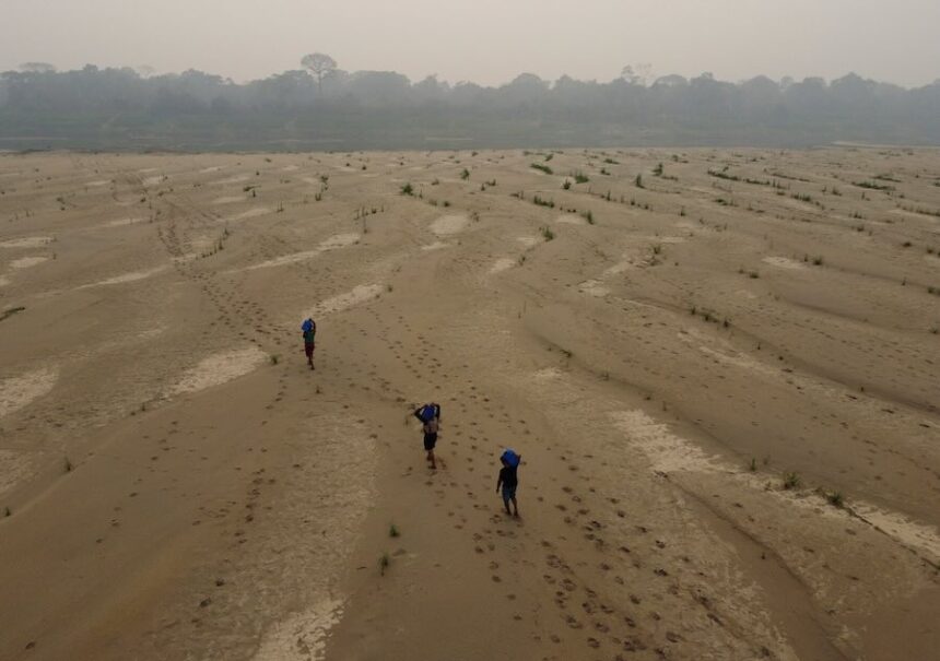 FILE - Residents transport drinking water from Humaita to the Paraizinho community, along the dry Madeira River, a tributary of the Amazon River, during the dry season, Amazonas state, Brazil, Sept. 8, 2024.