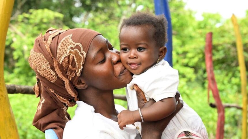 Laveille cuddles her 6-month-old baby, Korotoum, in Côte d’Ivoire.