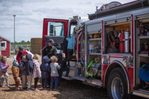 Students climb into a firetruck outside American Heritage Charter School on Monday. | Cody Roberts, EastIdahoNews.com