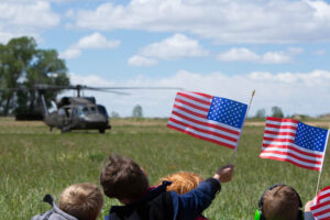 Students wave flags while watching a Black Hawk helicopter near American Heritage Charter School. | Cody Roberts, EastIdahoNews.com