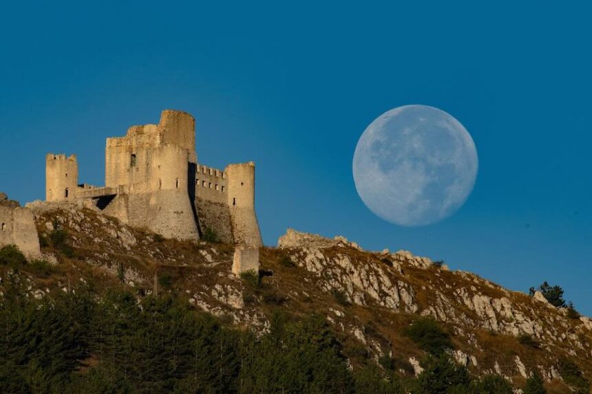 A full sturgeon supermoon, also a blue moon, sets behind Rocca Calascio Castle in Calascio, Italy, in August 2024.
