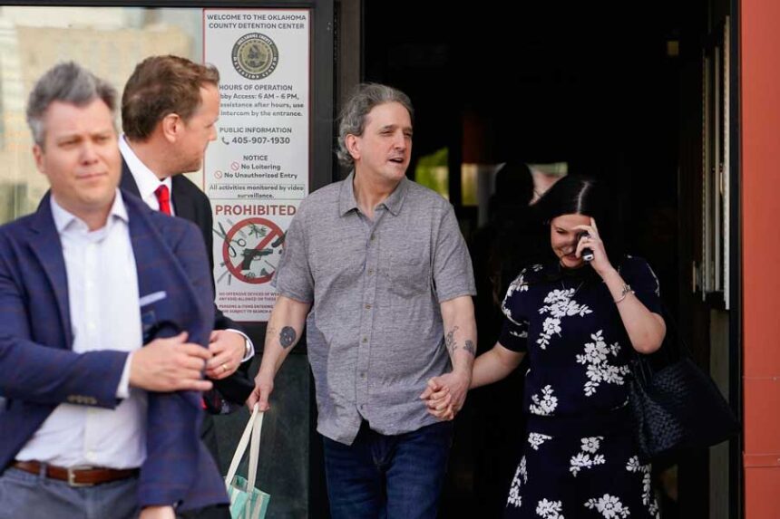 Former Oklahoma death row inmate Richard Glossip, center, exits a detention facility Thursday alongside his wife after being granted bond while awaiting retrial.