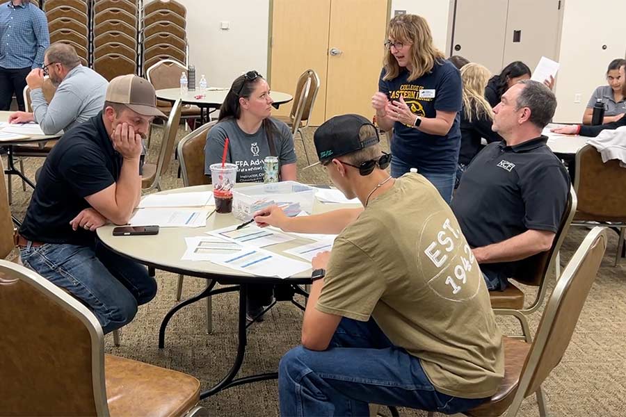 Heidi Codling, center, standing next to the table, speaking to one of the judges during the robotics challenge. | Rett Nelson, EastIdahoNews.com