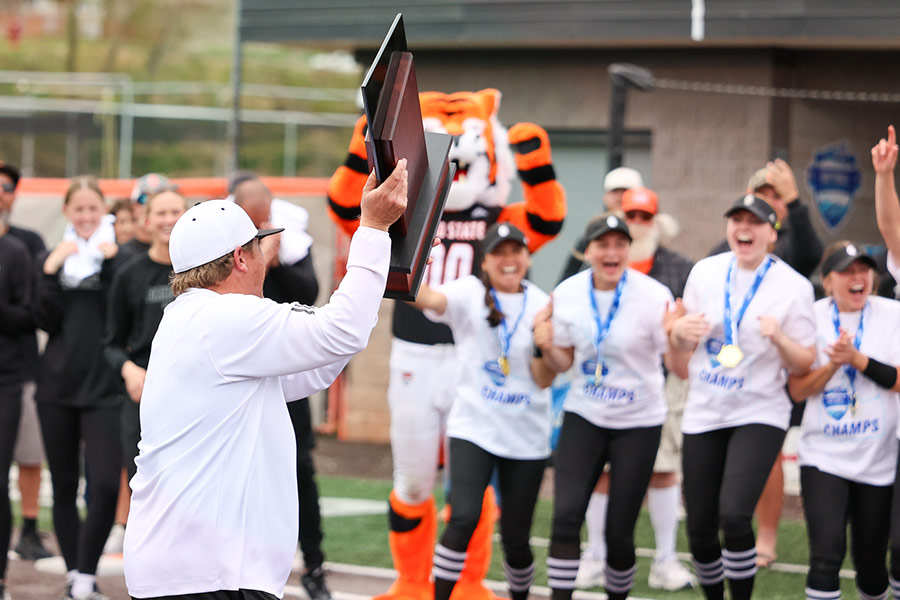 ISU head softball coach Andrew Rich accepts the Big Sky Conference tournament championship trophy