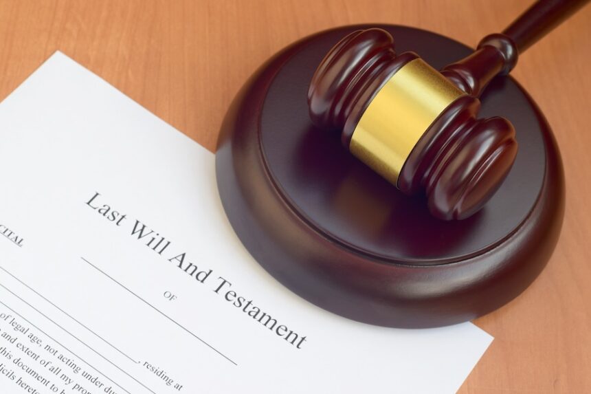 Justice mallet and Last Will and Testament blank document on wooden court table close up. (Envato Elements)