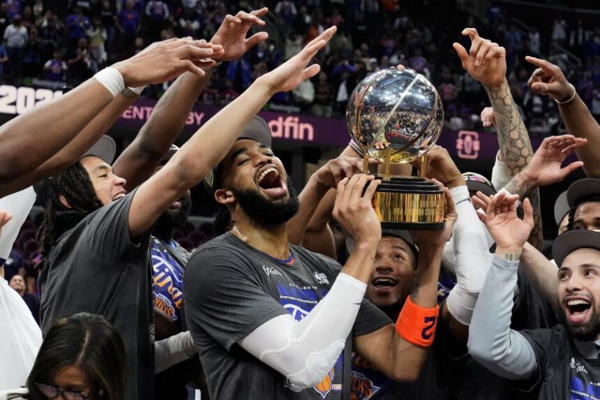 New York Knicks center Karl-Anthony Towns, center, and teammates celebrate after winning Game 4 in the Eastern Conference finals NBA basketball playoffs series against the Cleveland Cavaliers in Cleveland, Monday, May 25, 2026. (AP Photo/Sue Ogrocki)