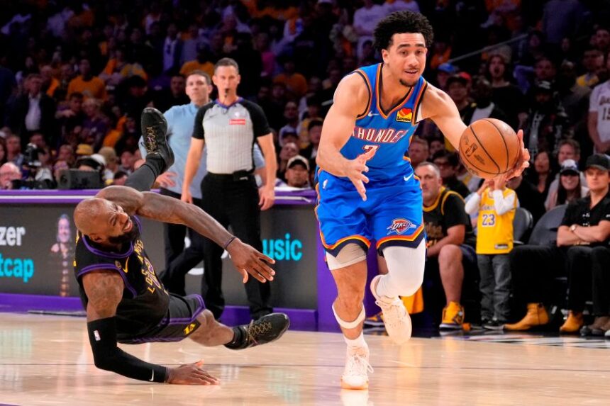 Oklahoma City Thunder guard Jared McCain, right, drives toward the basket as Los Angeles Lakers forward LeBron James falls during the second half of Game 4 in a second-round NBA basketball playoffs series Monday, May 11, 2026, in Los Angeles. (AP Photo/Mark J. Terrill)