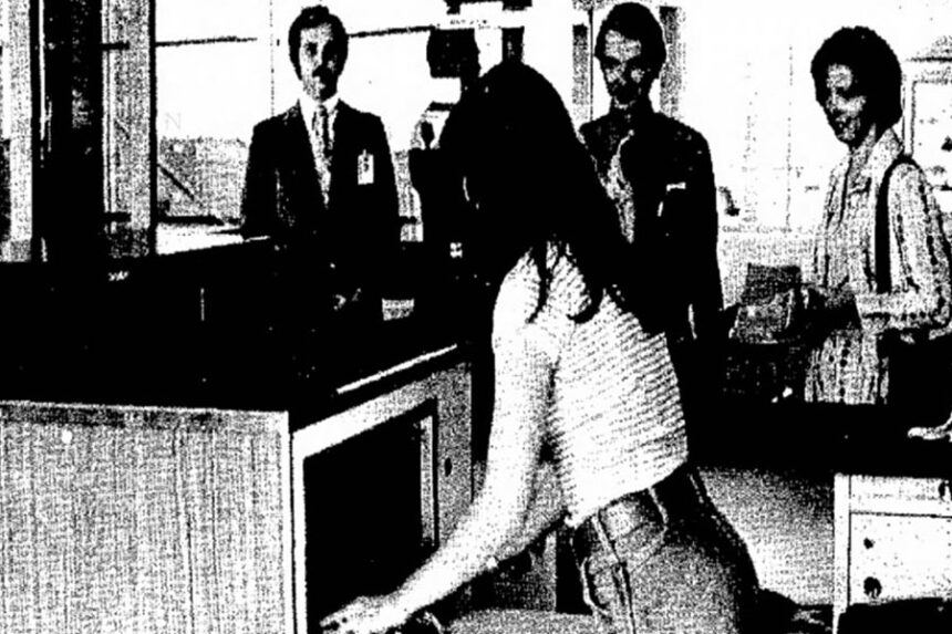 Western Airlines employee Leah Cameron places luggage in Western's new X-ray machine at the Pocatello Airport. Jill Smith, right, and Al Francisco, center, both of the ISU College of Business, wait for their carry-on luggage before flying to a convention for business students. Doug Cain, left, Western's local manager, observes the operation. After placing baggage in the machine, Cameron presses a button and an image of the luggage's interior is projected on a screen. All Western employees involved with luggage have been thoroughly trained to read the X-ray screens, Cain says, to detect objects like guns. "It really speeds up the pre-screening process," he says, explaining, "We no longer have to open their luggage or packages." Caption dated April 8, 1977.